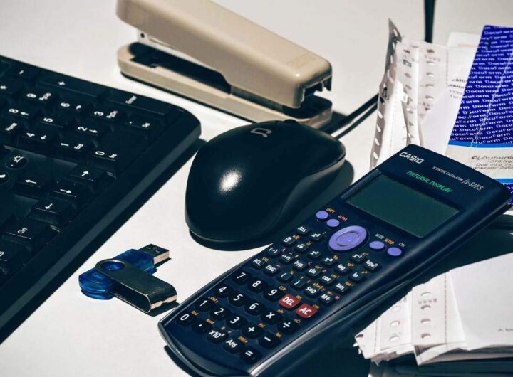 Clavier, souris, calculatrice, agrafeuse, clé USB, papiers sur un bureau