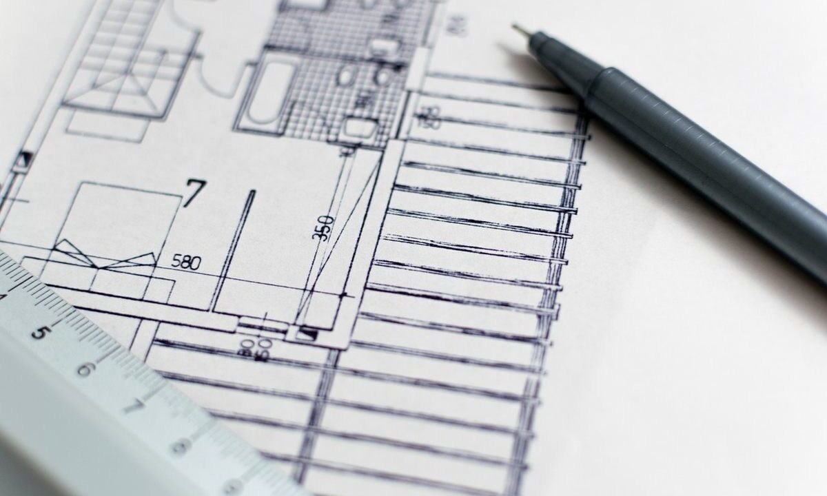 Feuille de plan, stylo et règle posés sur papier blanc