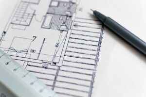 Feuille de plan, stylo et règle posés sur papier blanc