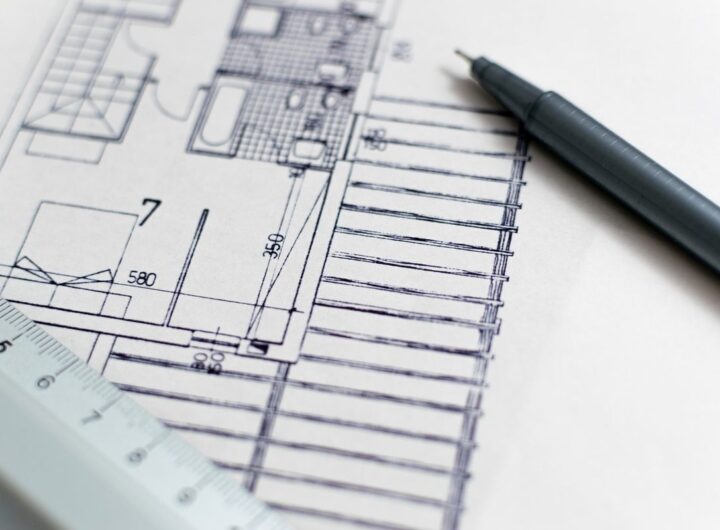 Feuille de plan, stylo et règle posés sur papier blanc