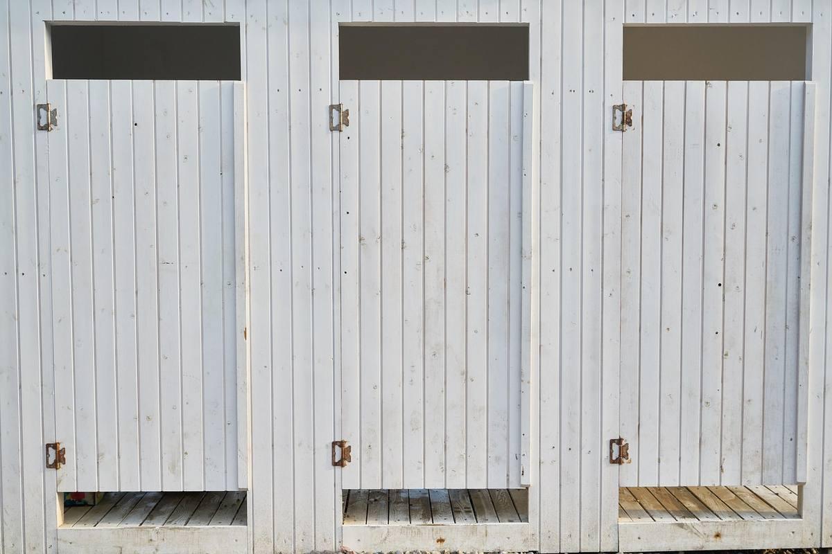 Trois portes de garage métalliques blanches montrant des traces de rouille et d'humidité en bord de mer Trois portes de garage métalliques blanches montrant des traces de rouille et d'humidité en bord de mer
