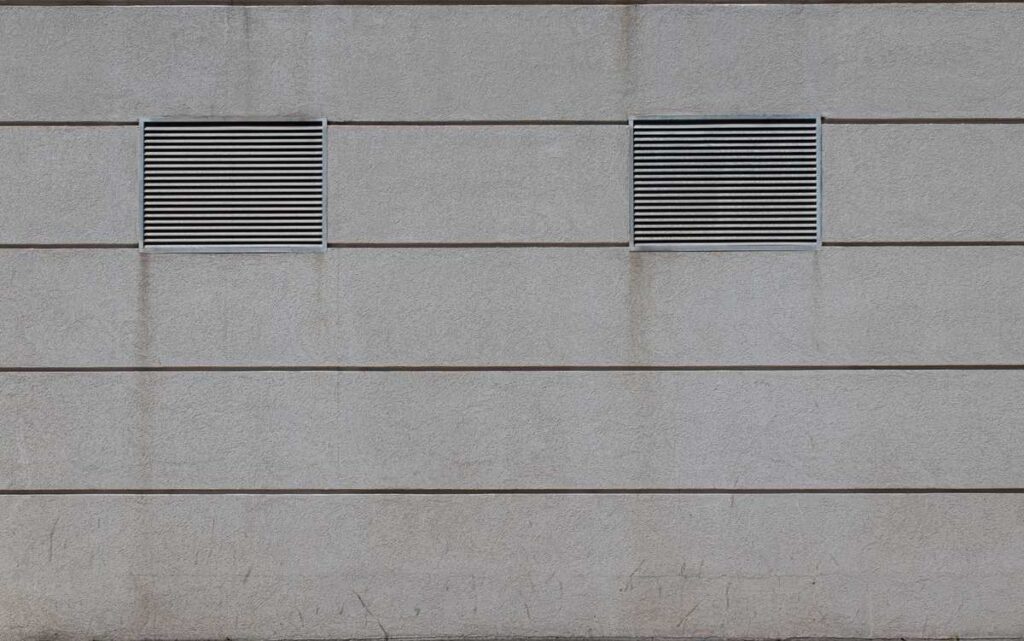 Deux grilles d'aération sur un mur en béton