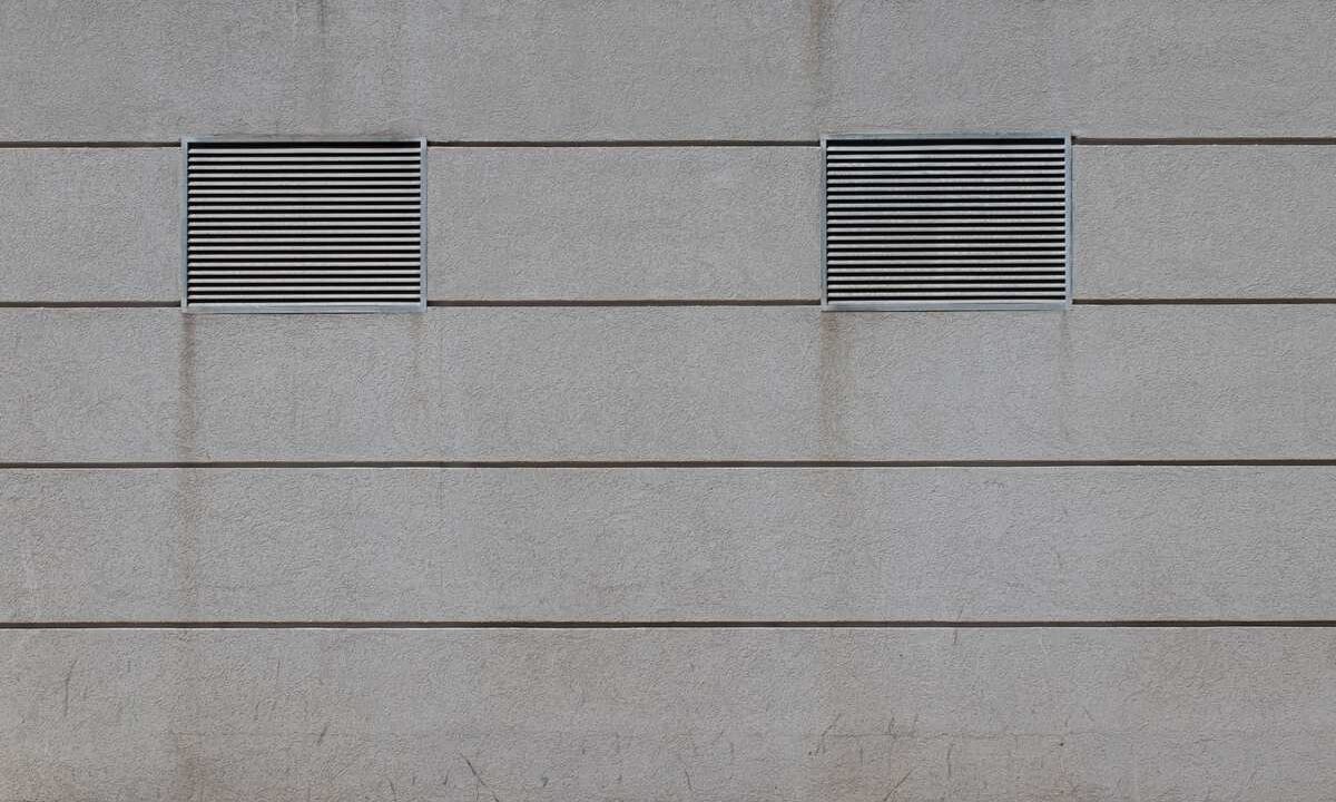 Deux grilles d'aération sur un mur en béton