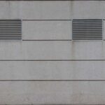 Deux grilles d'aération sur un mur en béton