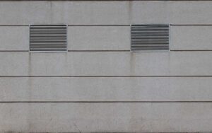 Deux grilles d'aération sur un mur en béton